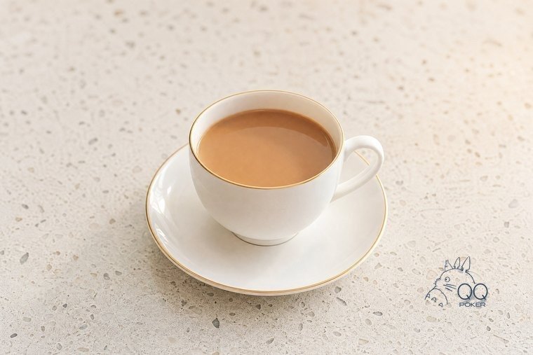 米白水磨石台面上一只素白骨瓷咖啡杯与杯碟,斜四十五度俯视